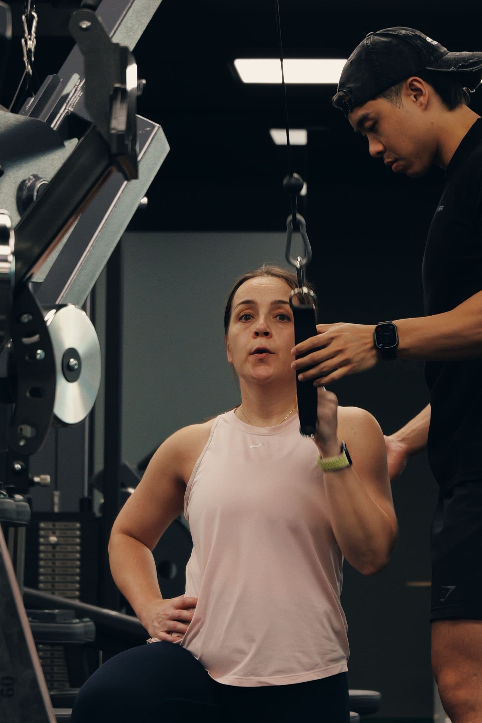 Catalyst Performance female member on a cable machine with a coach giving 1:1 attention, Singapore CBD personal training studio