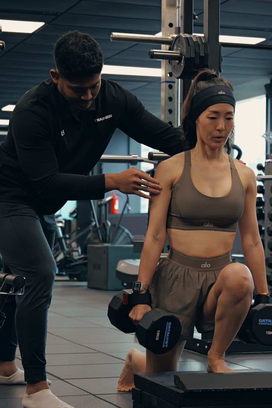 A Catalyst Performance coach demonstrating a dumbbell strength movement