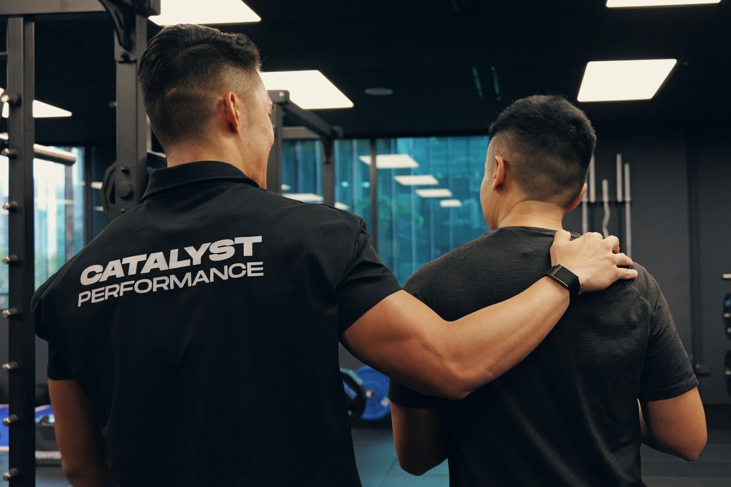 Catalyst Performance coach guiding a member at the rack, private 1:1 personal training in Singapore CBD