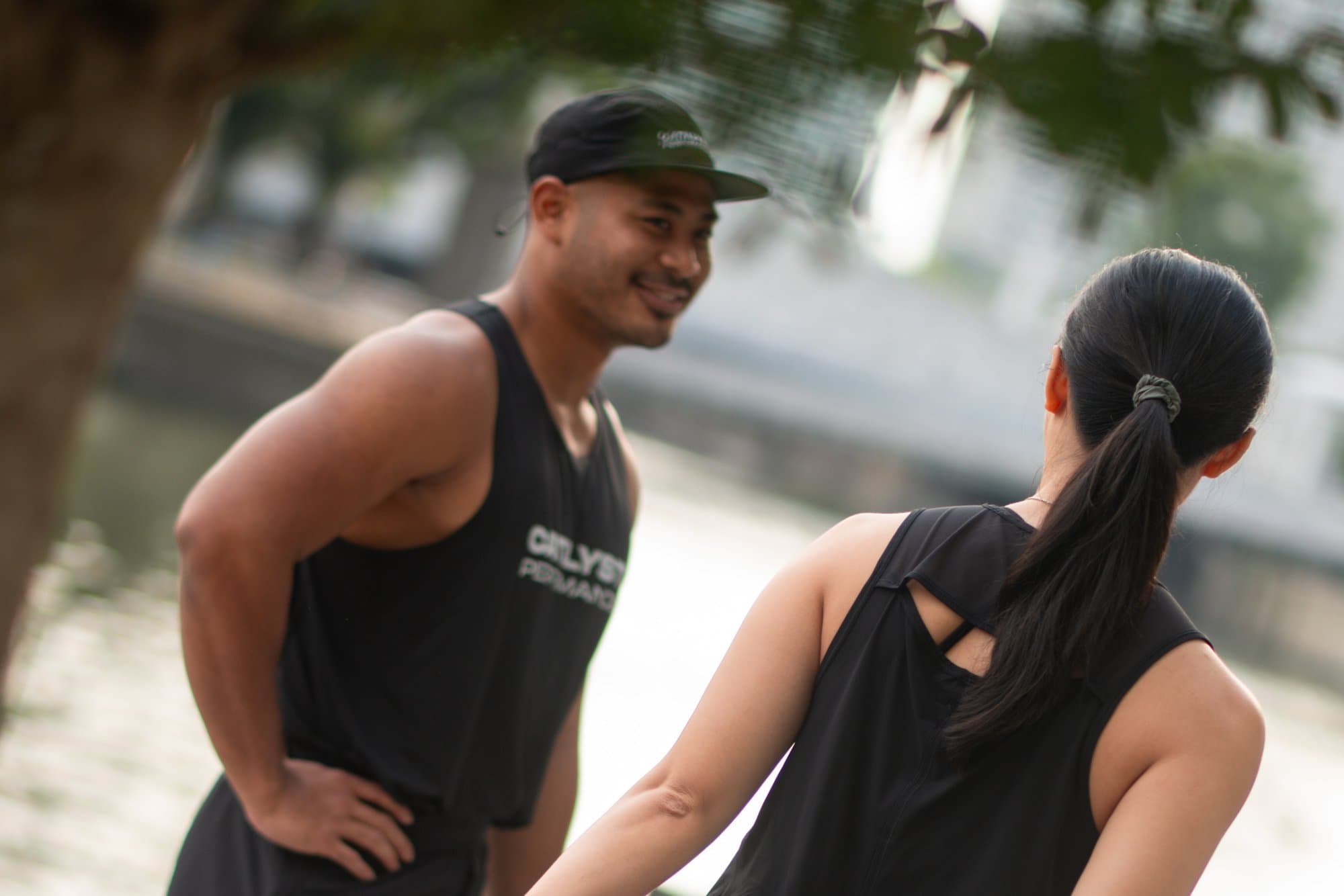 Catalyst Performance run club: a couple stretching together by the water after a run, Singapore