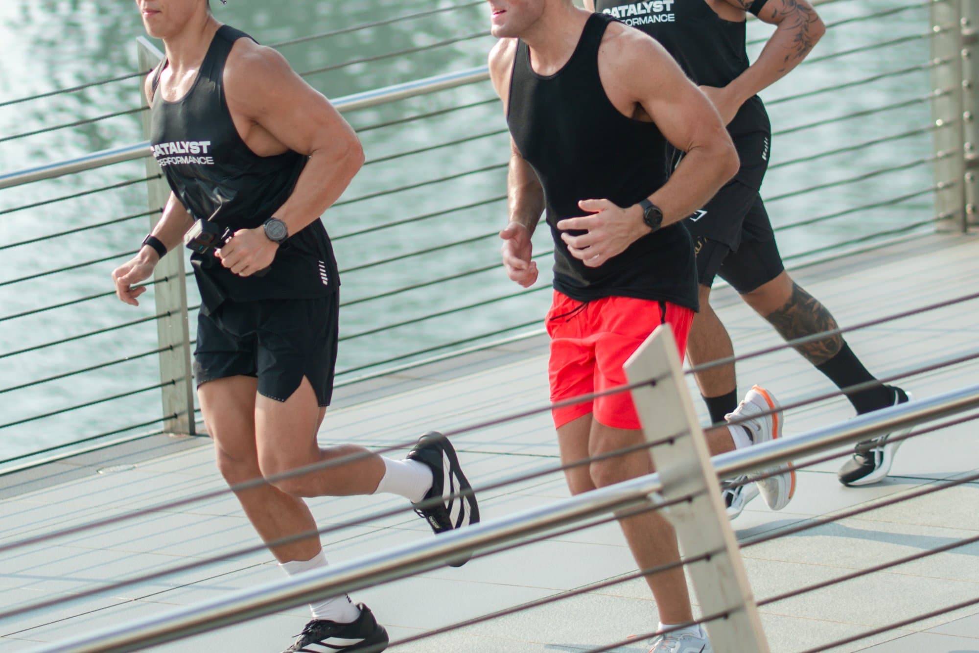 Catalyst Performance run club: members running in stride along a Singapore waterfront promenade