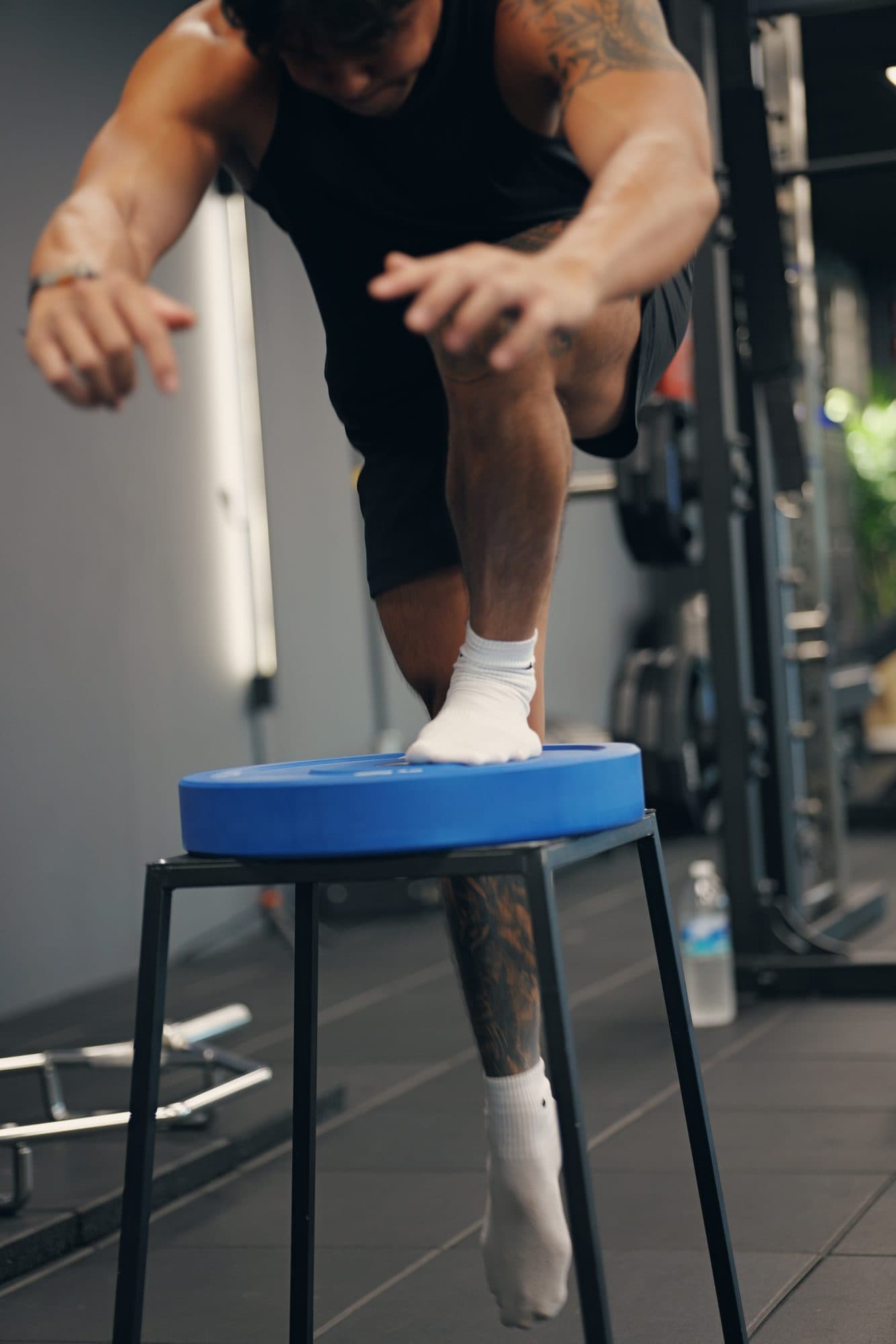 Single-leg step-up onto a box at Catalyst Performance, the coach's hand guiding the movement