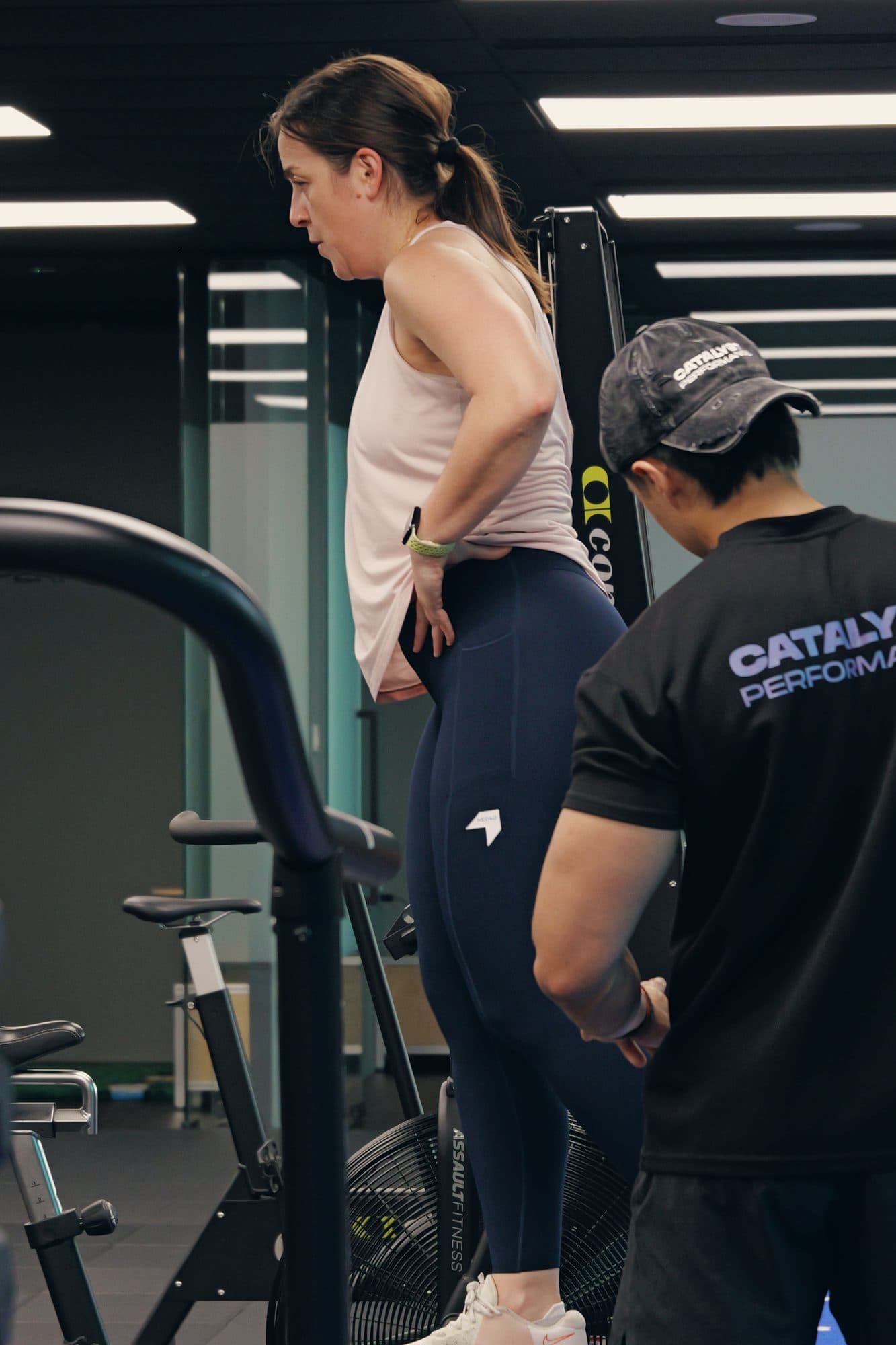 Catalyst coach in the studio shirt setting up a client on a machine, Singapore CBD studio