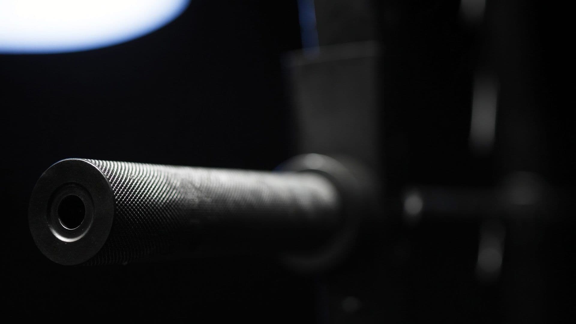 Close-up of hand-picked Watson UK strength platform detail in a private Singapore CBD personal training studio, cinematic charcoal and steel-blue palette