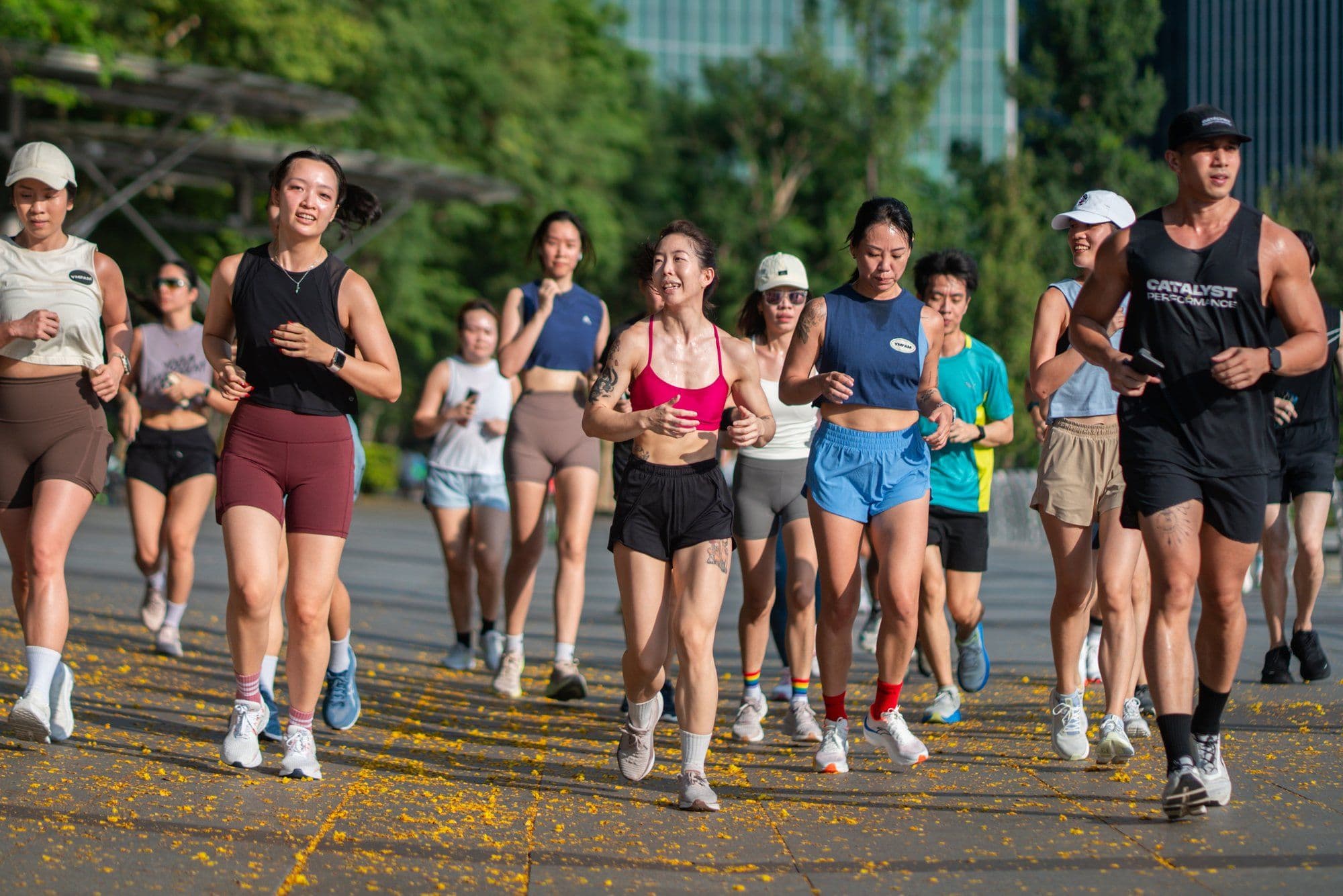 Catalyst run club members running together on a tree-lined Singapore park path