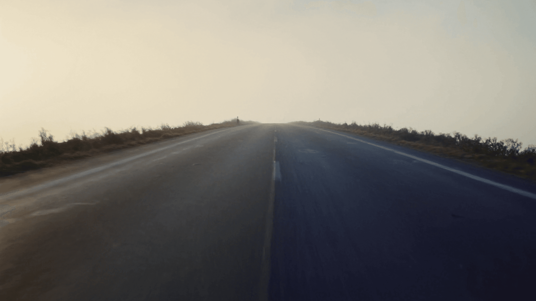 A long empty road stretching into soft dawn mist toward a bright horizon, the road back to running after injury