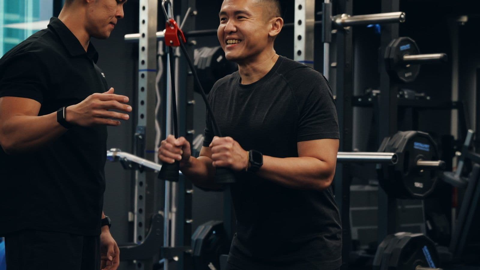 A Catalyst Performance coach working 1:1 with a client at a cable station in the Singapore CBD studio