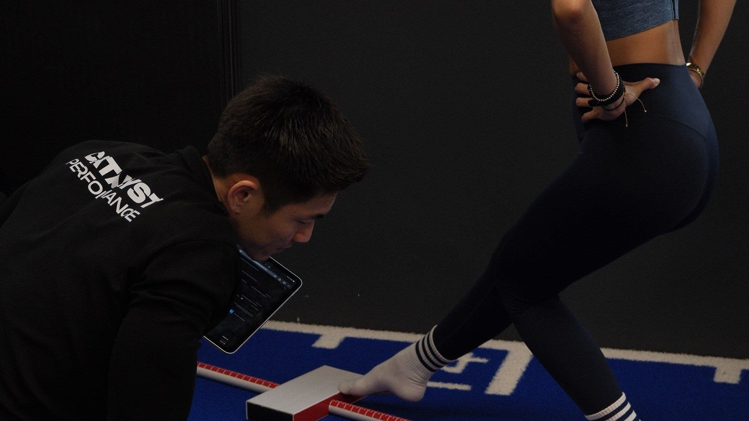 A Catalyst coach recording data on a tablet during a real Y-balance assessment in the studio