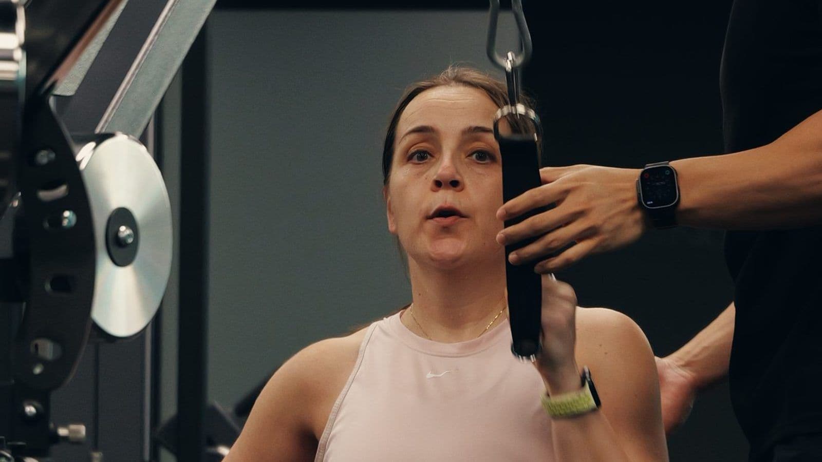 A woman in her 40s trains on a cable machine with a Catalyst coach at the studio in Singapore CBD