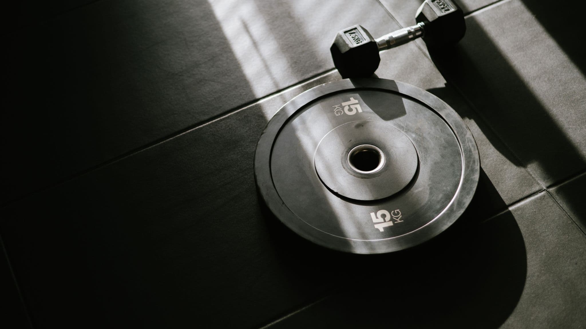 A Catalyst Performance coach spotting a client through a heavy barbell back squat in the Manulife Tower studio, the kind of high-load resistance work that protects bone density during GLP-1 weight loss