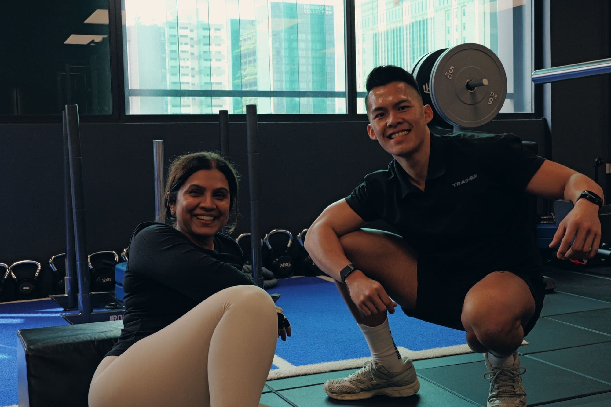 Client and coach in a private training studio with the Singapore skyline behind them