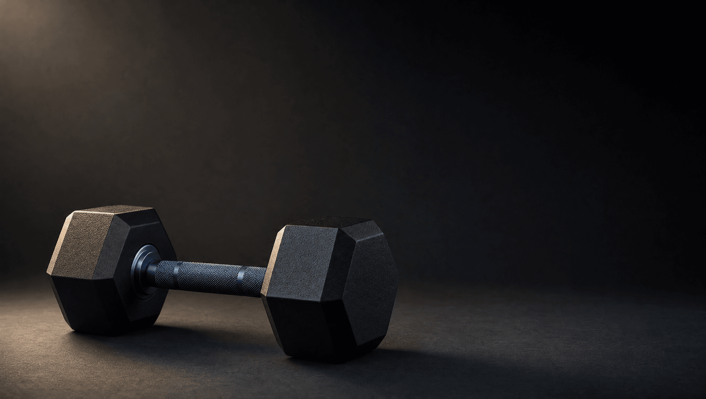 A single premium dumbbell under a studio spotlight on a charcoal surface