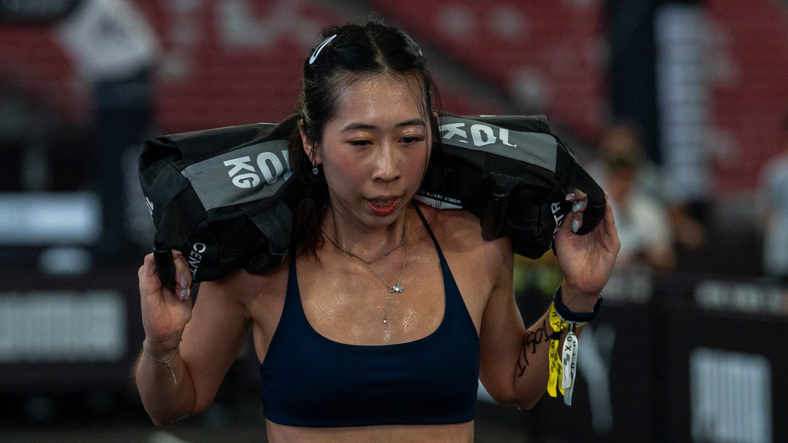 An athlete carrying a sandbag at an AIA HYROX Singapore station